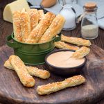 Homemade savory bread sticks with cheese and sesame in a basket,