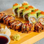 Plate with an assortment of colorful Japanese sushi rolls, topped with fish roe, sesame seeds