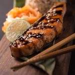 Teriyaki salmon with rice on a wooden platter. Top view.