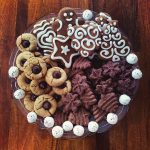 Tray of homemade holiday cookies such as iced gingerbread, spritz, kiss cookies and truffles.